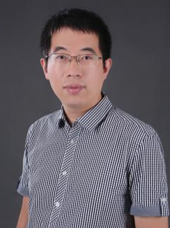 四十五岁左右男性技术专家肖像,穿浅色衬衫,黑色外套,背景为实验室